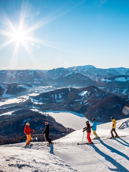 Gruppe von Skifahrern auf der Gemeindealpe. Im Hintergrund Blick auf die verschneite Landschaft und den Erlaufsee