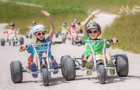 Zwei Teenager haben eine lustige Abfahrt auf den Mountaincarts