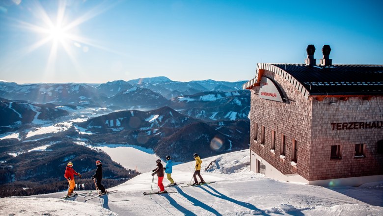 Gruppe von Skifahrern auf der Gemeindealpe. Im Hintergrund Blick auf die verschneite Landschaft und den Erlaufsee