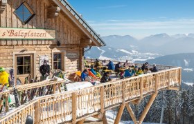 Hütte s'Balzplatzerl mit Gästen die auf der Sonnenterrasse sitzen