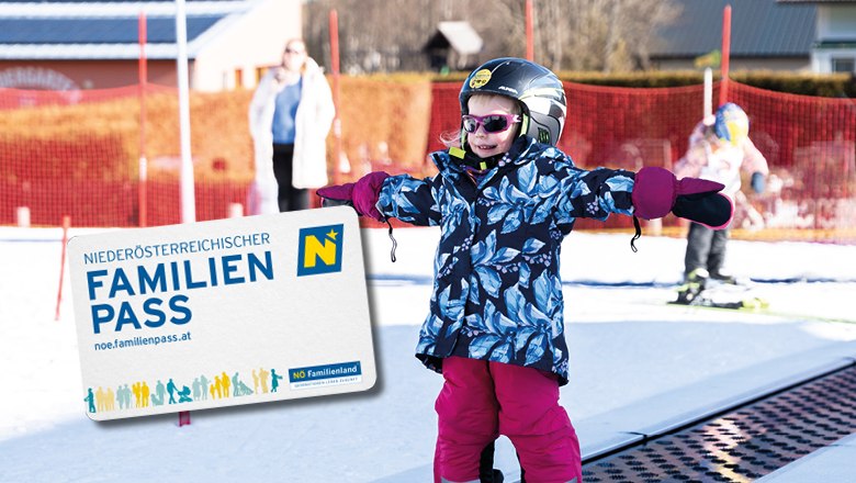 Kleines Mädchen mit Skiern steht am Zauberteppich