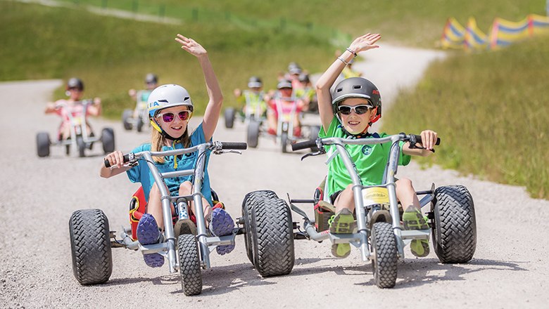 Zwei Teenager haben eine lustige Abfahrt auf den Mountaincarts