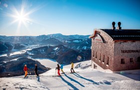 Gruppe von Skifahrern auf der Gemeindealpe. Im Hintergrund Blick auf die verschneite Landschaft und den Erlaufsee