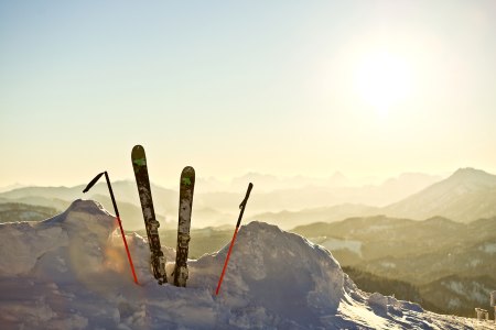 Skier in einem Schneehaufen mit Sonne im Hintergrund